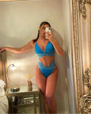 Person taking a mirror selfie wearing the blue mosaic bikini in a bedroom.